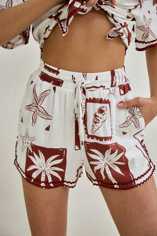 Image of a model wearing Pants. Productname: Heychic Mira Sea Shells Tropical Ric Rac Shorts in Brown colour by brand - Heychic