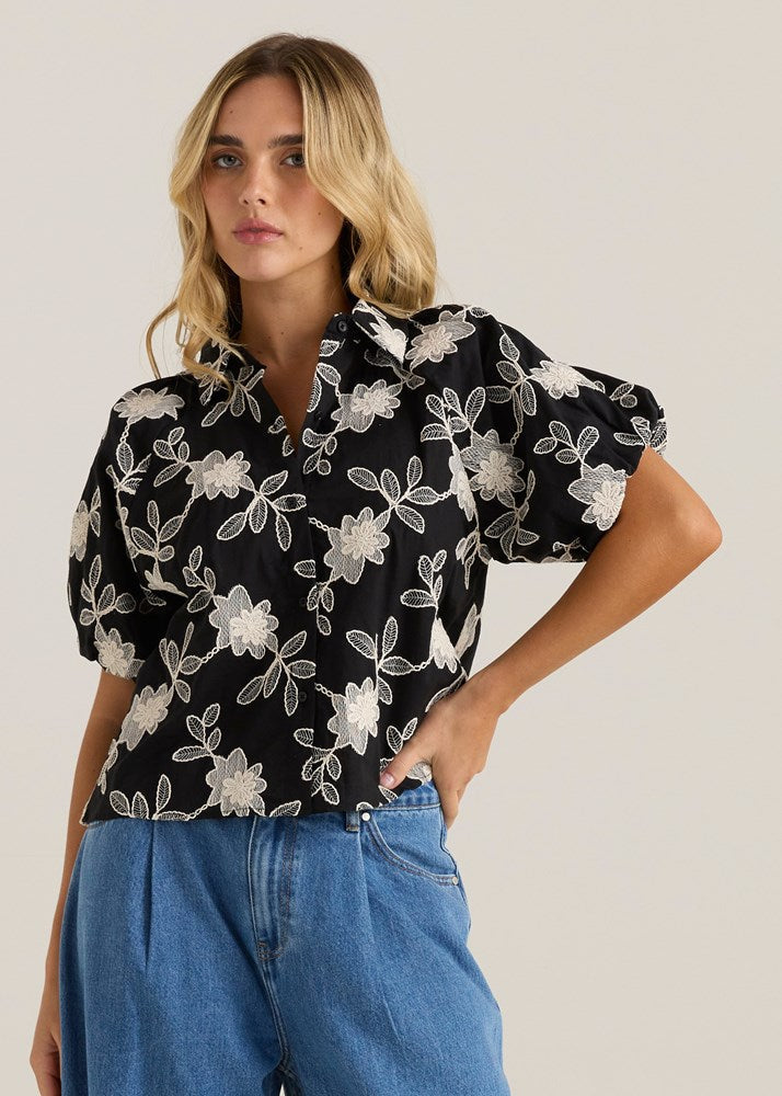 Image of a model wearing Tops. Product name - Marlowe Bubble Sleeve Blouse Black/Cream Floral in Black/ Cream Floral colour by brand - Sass Clothing