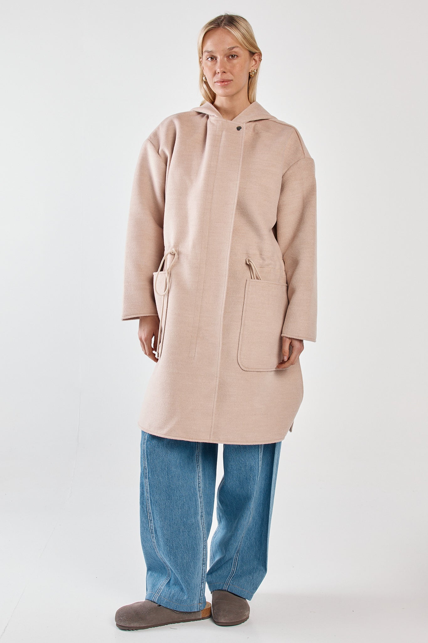 Image of a model wearing Outerwear. Product name - Maxi Hooded Coat Soft Oat in Soft Oat colour by brand - Sass Clothing
