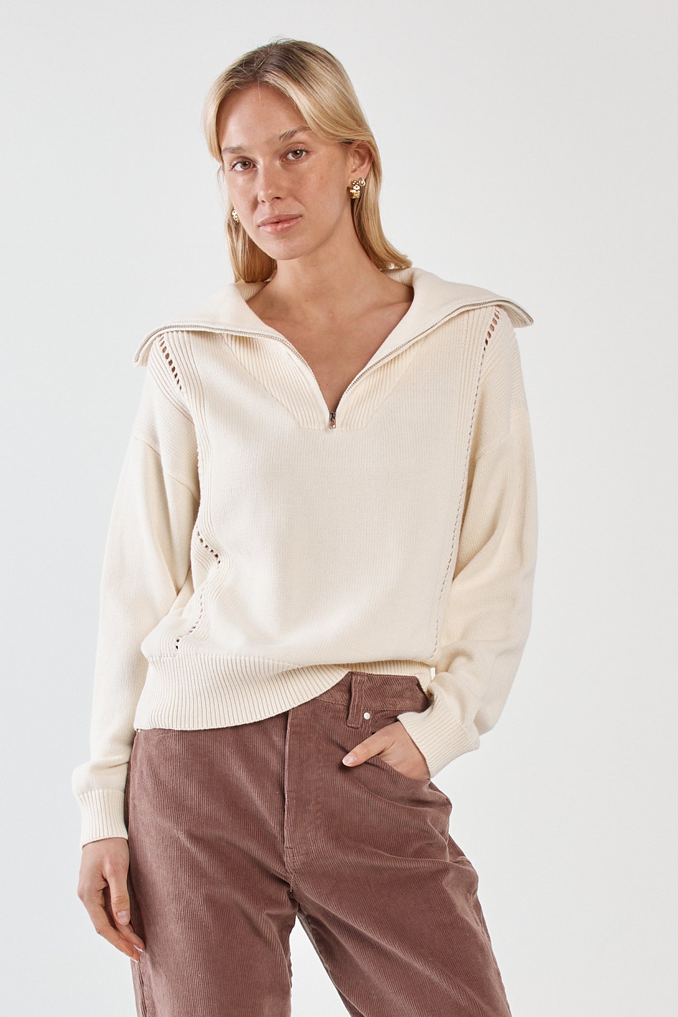 Image of a model wearing Tops. Product name - Esti Pointelle Zip Up Knit Cream in Cream colour by brand - Sass Clothing