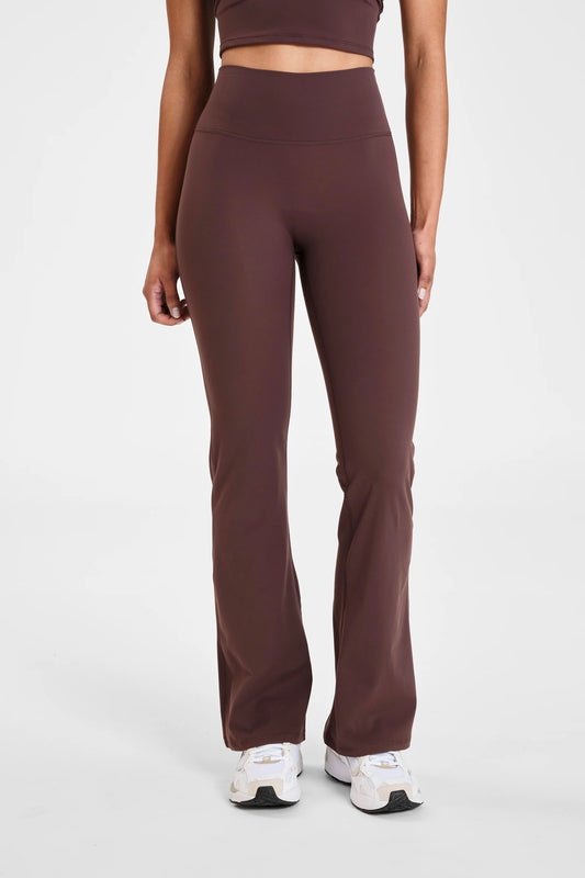 Image of a model wearing Pants. Product name - ALLFENIX CloudCore Flared Legging in Espresso colour by brand - All Fenix