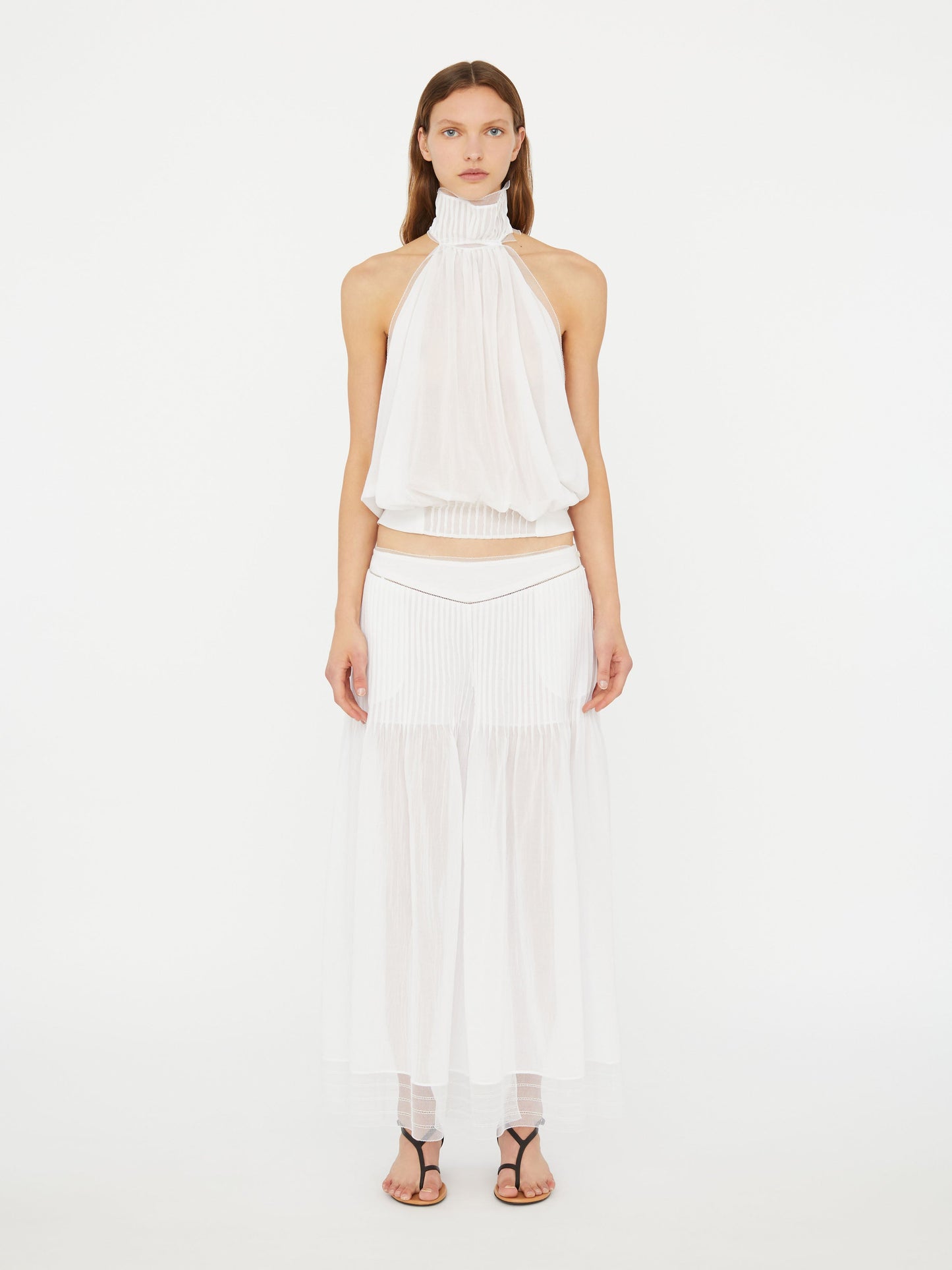 Image of a model wearing Pants. Product name - Vanished Pintucked Pant in White colour by brand - Christopher Esber
