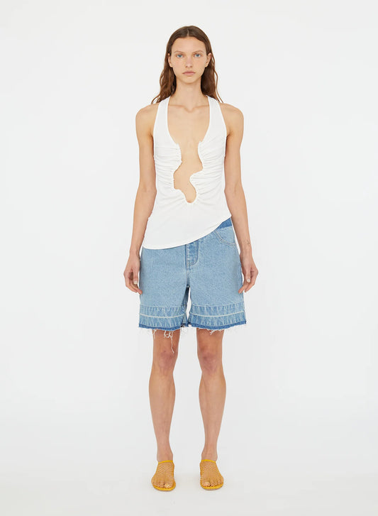 Image of a model wearing Shorts. Product name - Deconstruct Denim Short in Indigo colour by brand - Christopher Esber