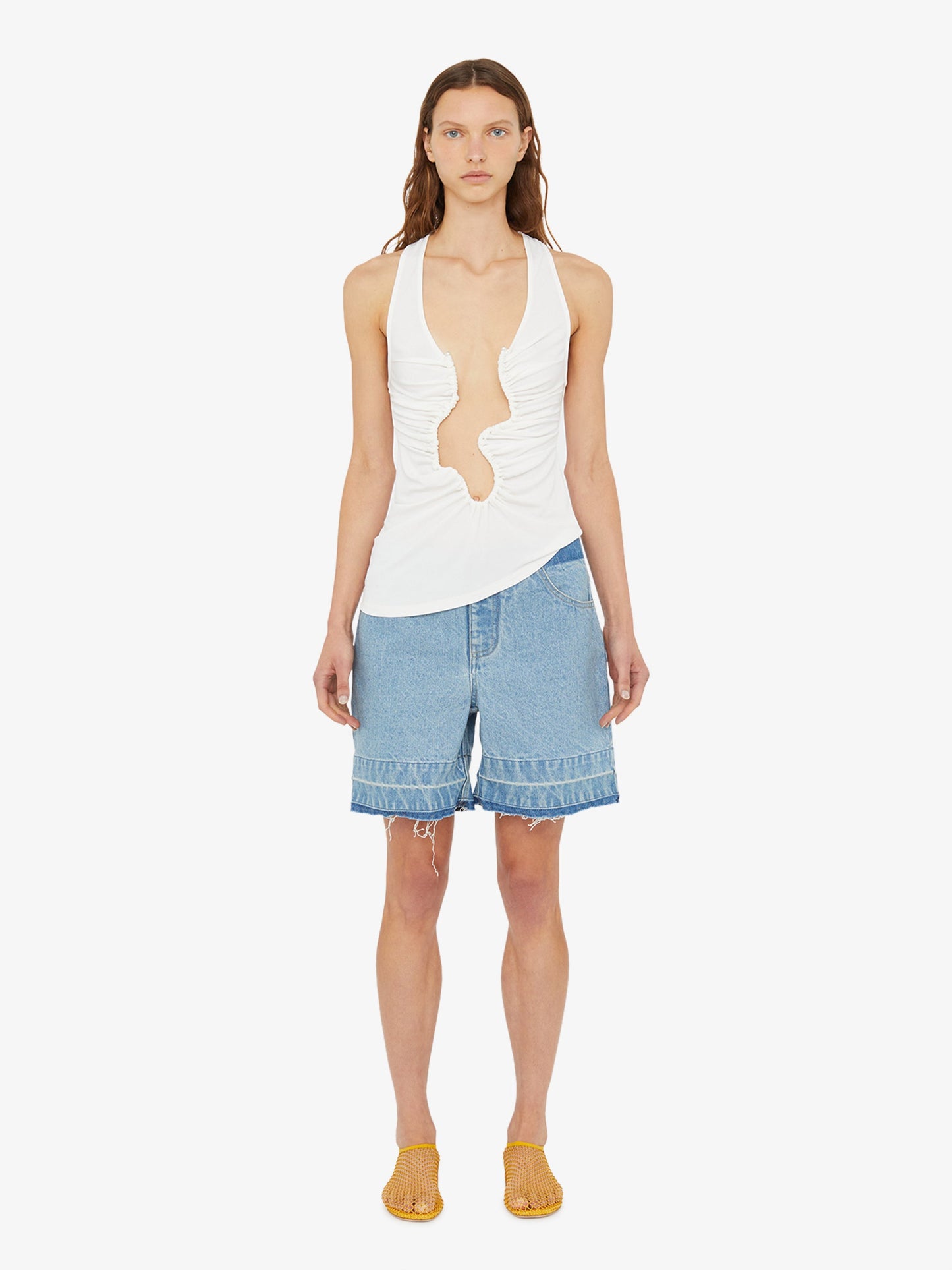 Image of a model wearing Shorts. Product name - Deconstruct Denim Short in Indigo colour by brand - Christopher Esber