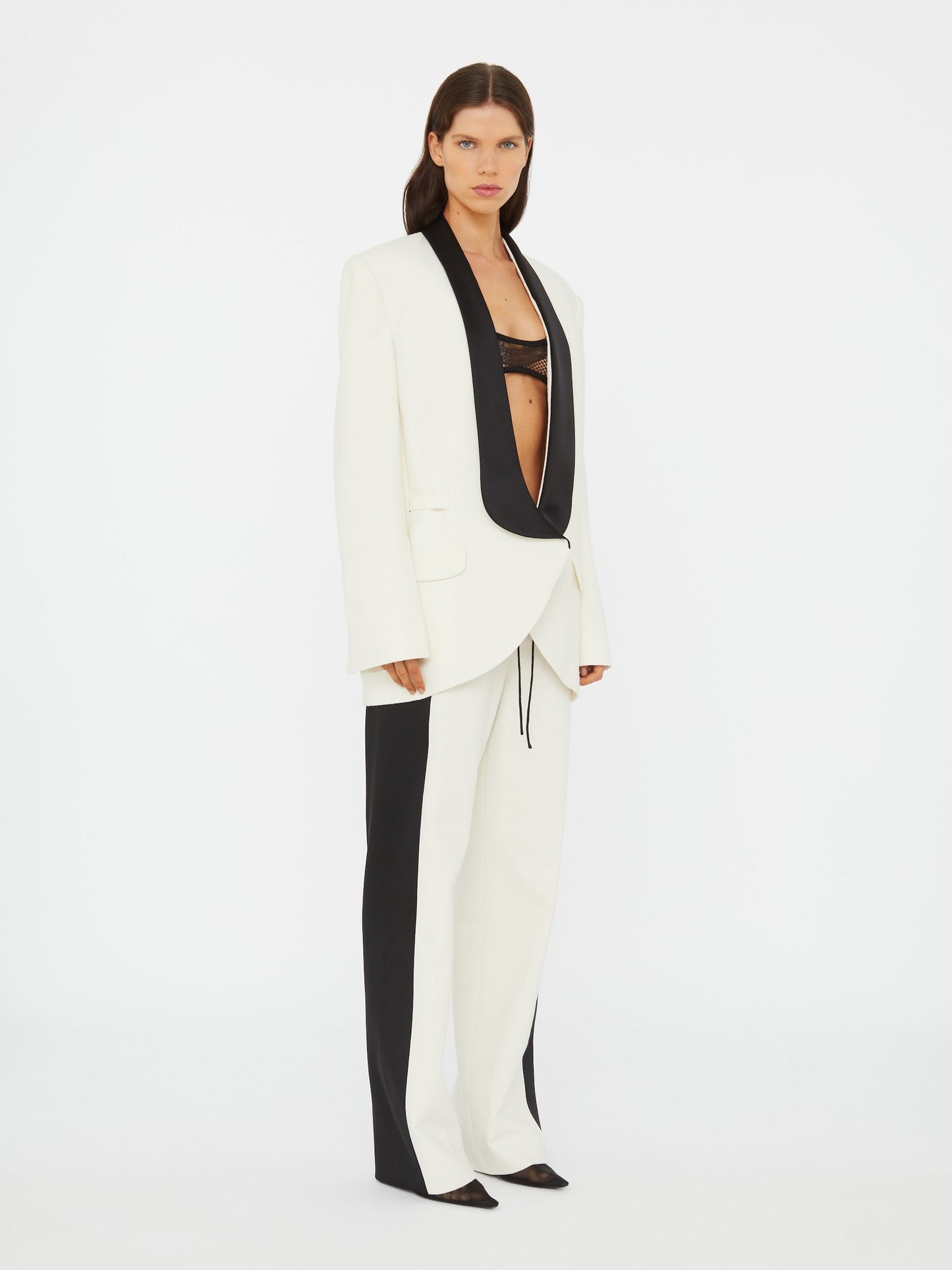 Image of a model wearing Pants. Product name - Tuxedo Contrast Silk Trouser in Black colour by brand - Christopher Esber