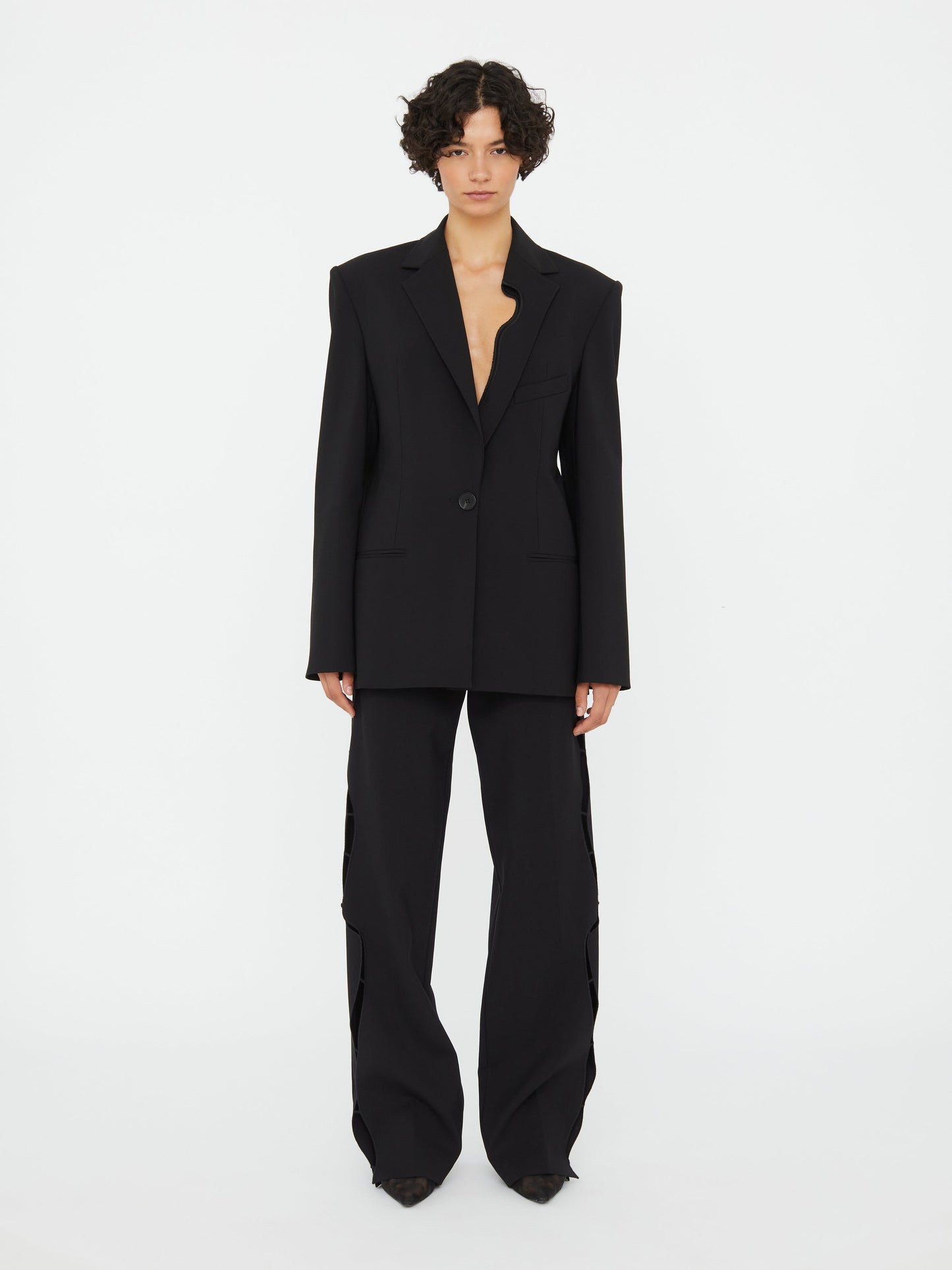 Image of a model wearing Outerwear. Productname: Christopher Esber Bitten Wool Blazer in Black colour by brand - Christopher Esber
