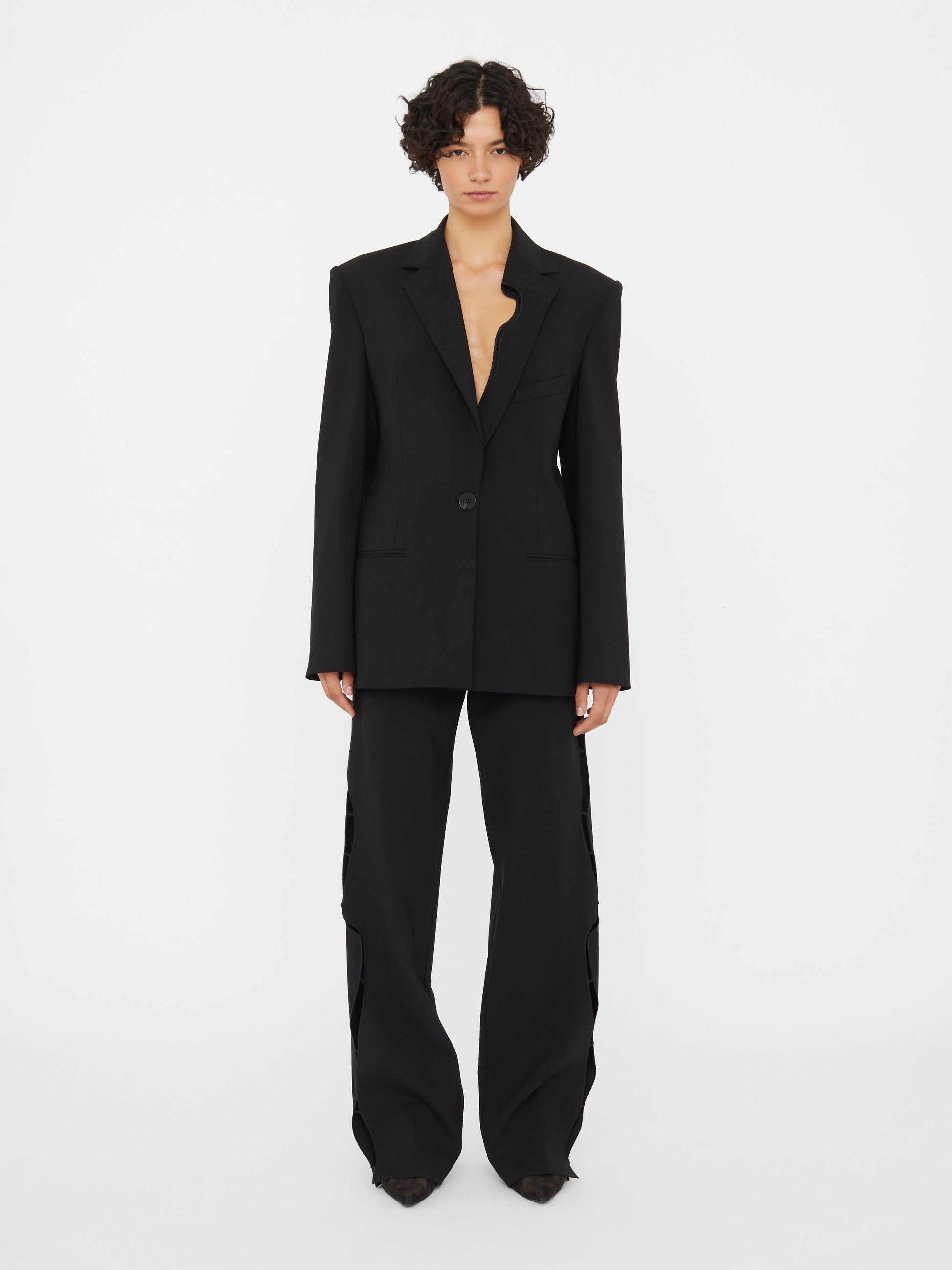 Image of a model wearing Outerwear. Productname: Christopher Esber Bitten Wool Blazer in Black colour by brand - Christopher Esber