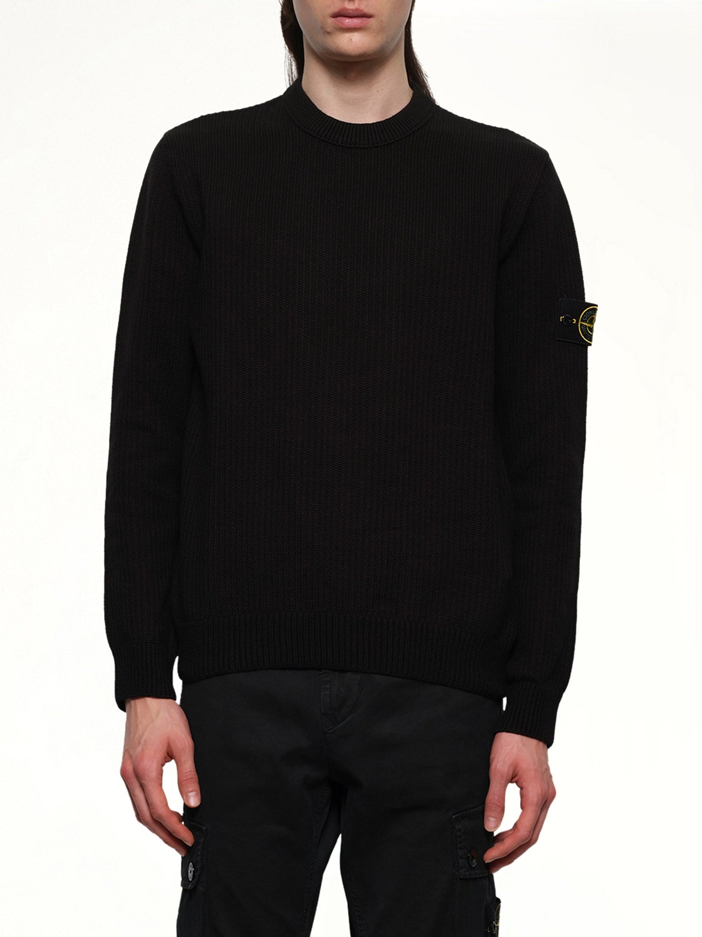Image of a model wearing Outerwear. Product name - 510004 Wool Crew Neck Sweater in Black colour by brand - STONE ISLAND