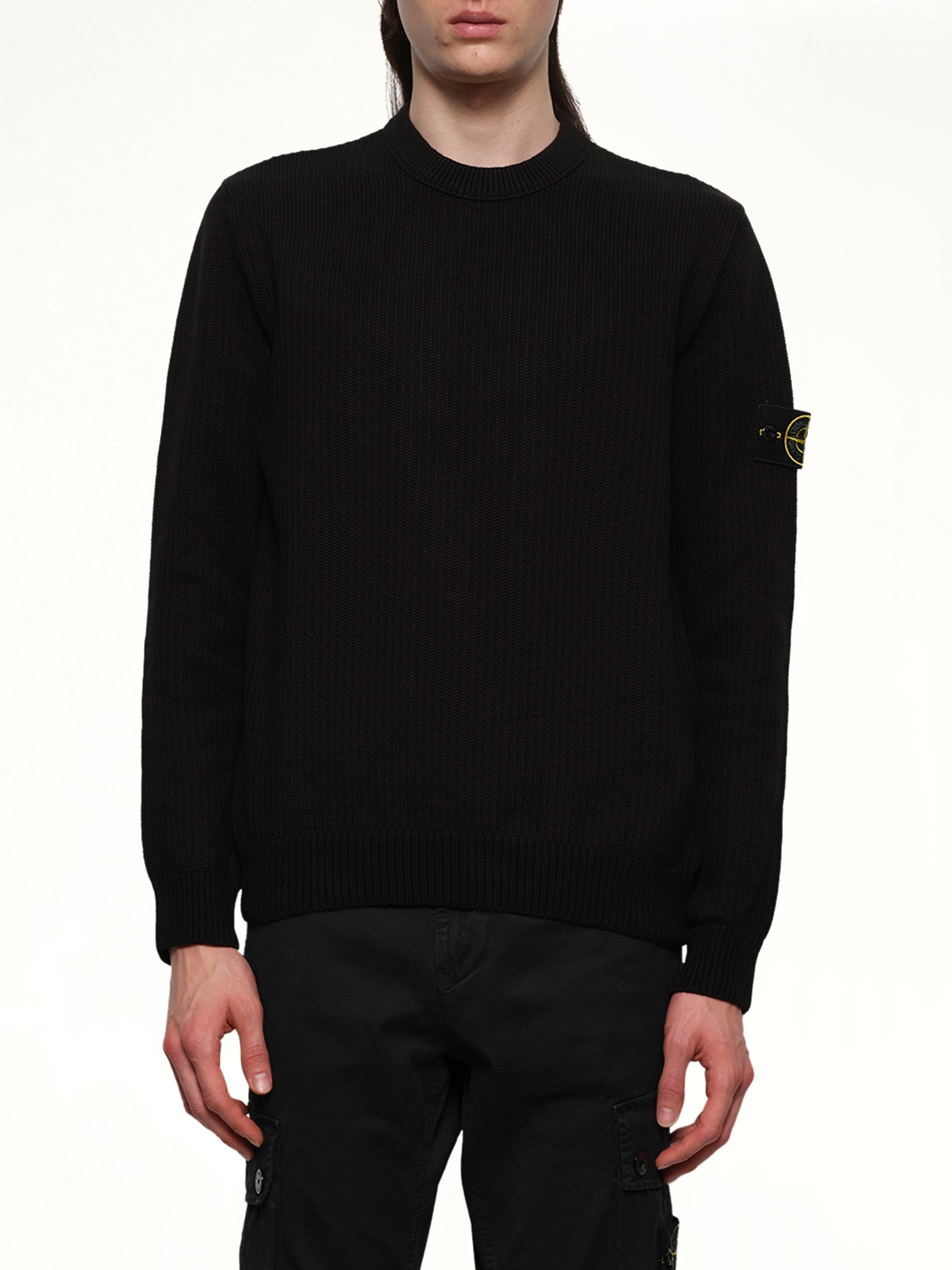 Image of a model wearing Outerwear. Product name - 510004 Wool Crew Neck Sweater in Black colour by brand - STONE ISLAND