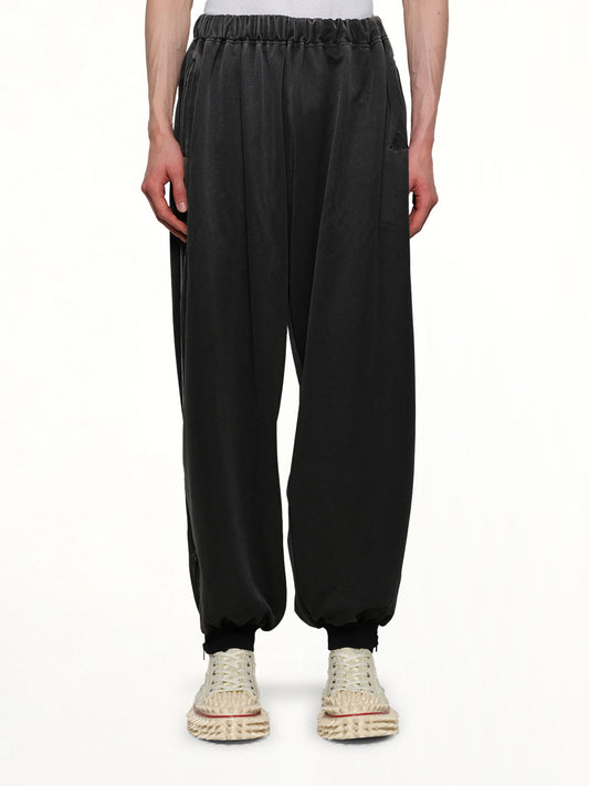 Image of a model wearing Pants. Productname: DOUBLET Faded Black Track Pants in GREY colour by brand - DOUBLET