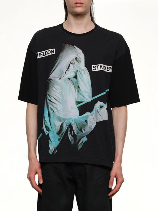 Image of a model wearing Tops. Productname: UNDERCOVER Heldon Stand By T-Shirt in BLACK colour by brand - UNDERCOVER