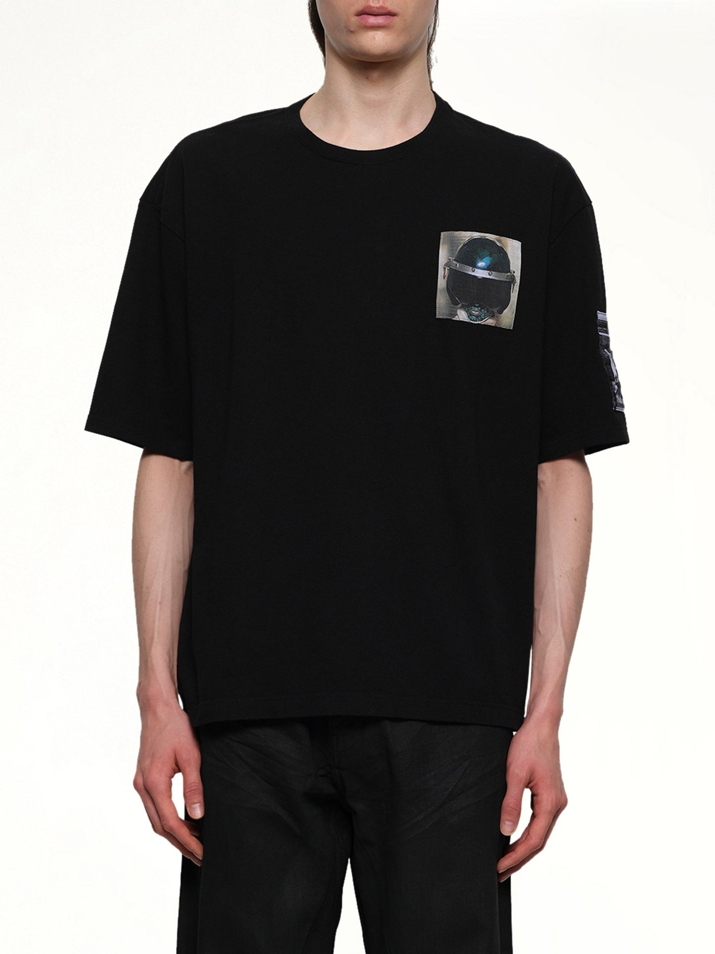 Image of a model wearing Tops. Productname: UNDERCOVER Heldon T-Shirt in BLACK colour by brand - UNDERCOVER