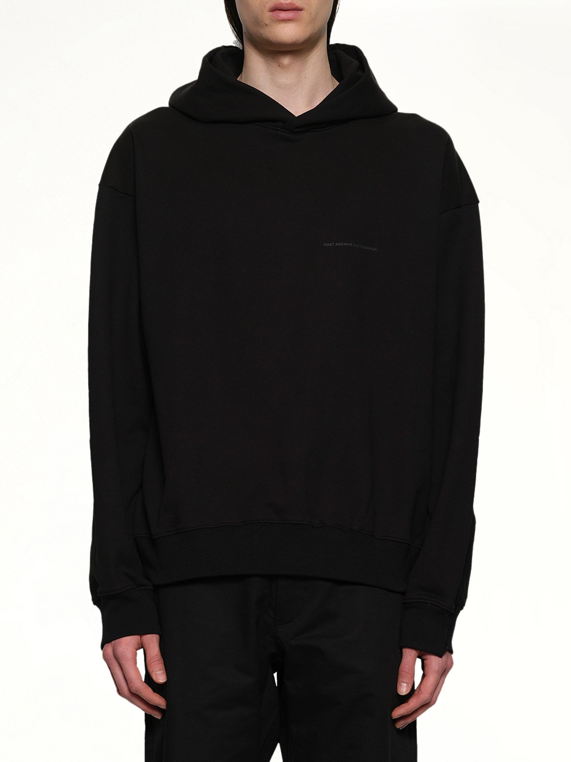Image of a model wearing Outerwear. Product name - Work Hoodie (Archive) in Black colour by brand - POST ARCHIVE FACTION