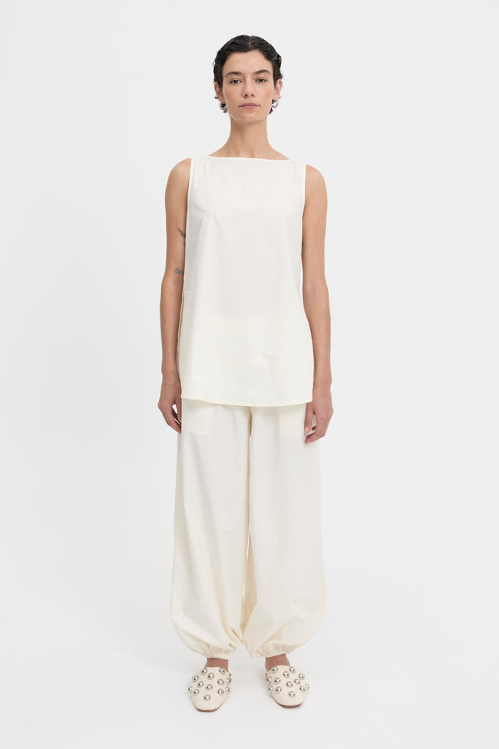 Image of a model wearing Pants. Product name - Yan Pants Cream in Cream colour by brand - Blanca Studio