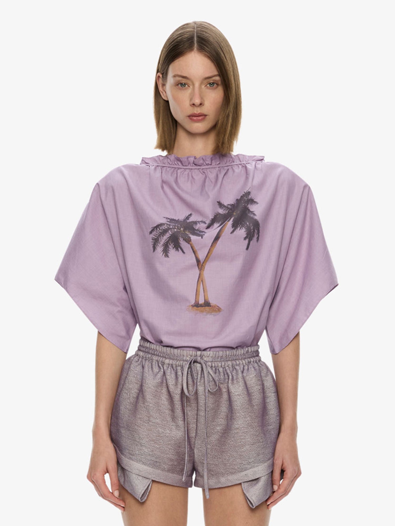Image of a model wearing Tops. Product name - Mirage Palm Poplin Top in Lilac colour by brand - CHRISTOPHER ESBER