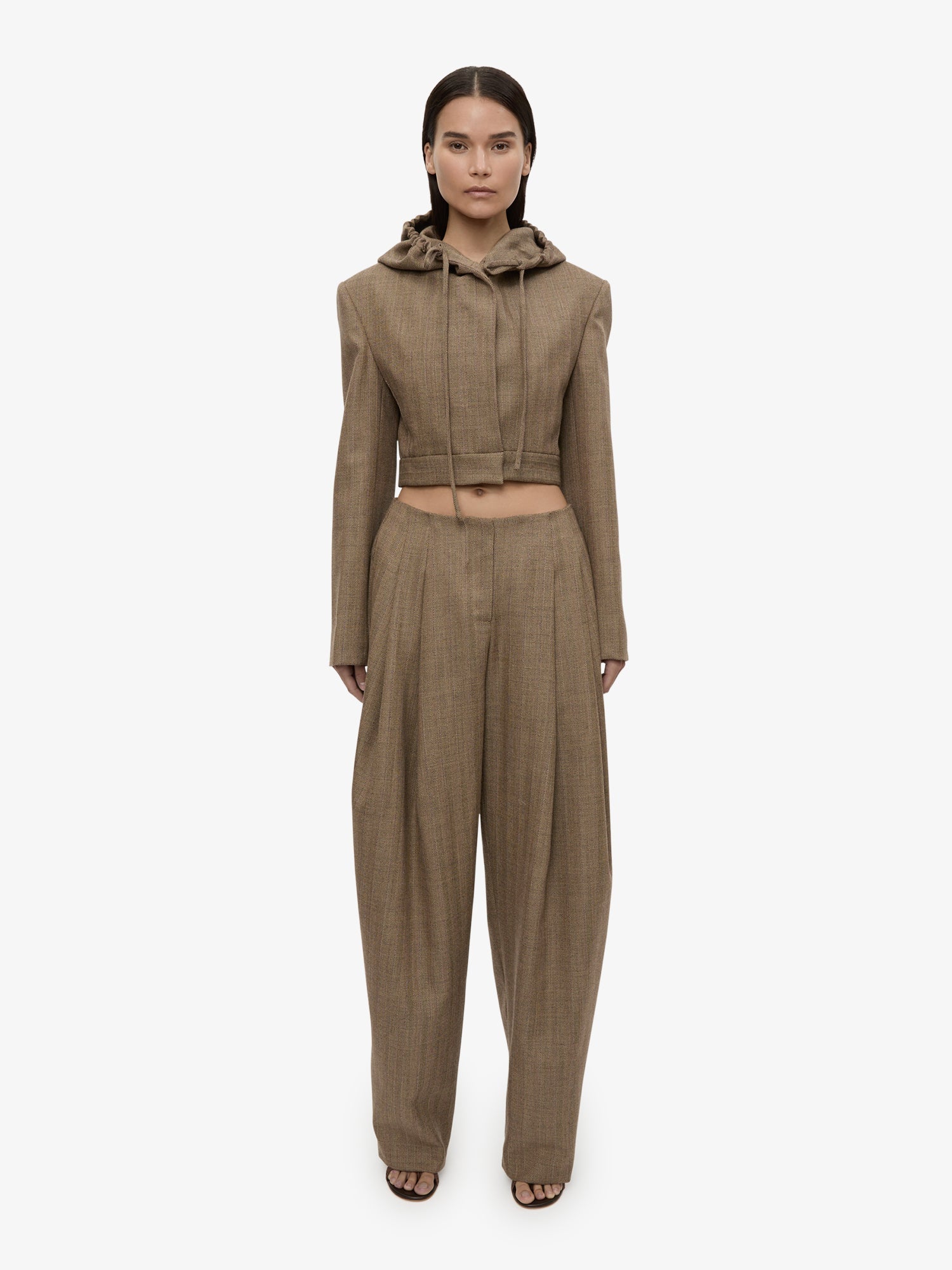 Image of a model wearing Pants. Product name - Plinth Herringbone Trouser in Brown colour by brand - CHRISTOPHER ESBER