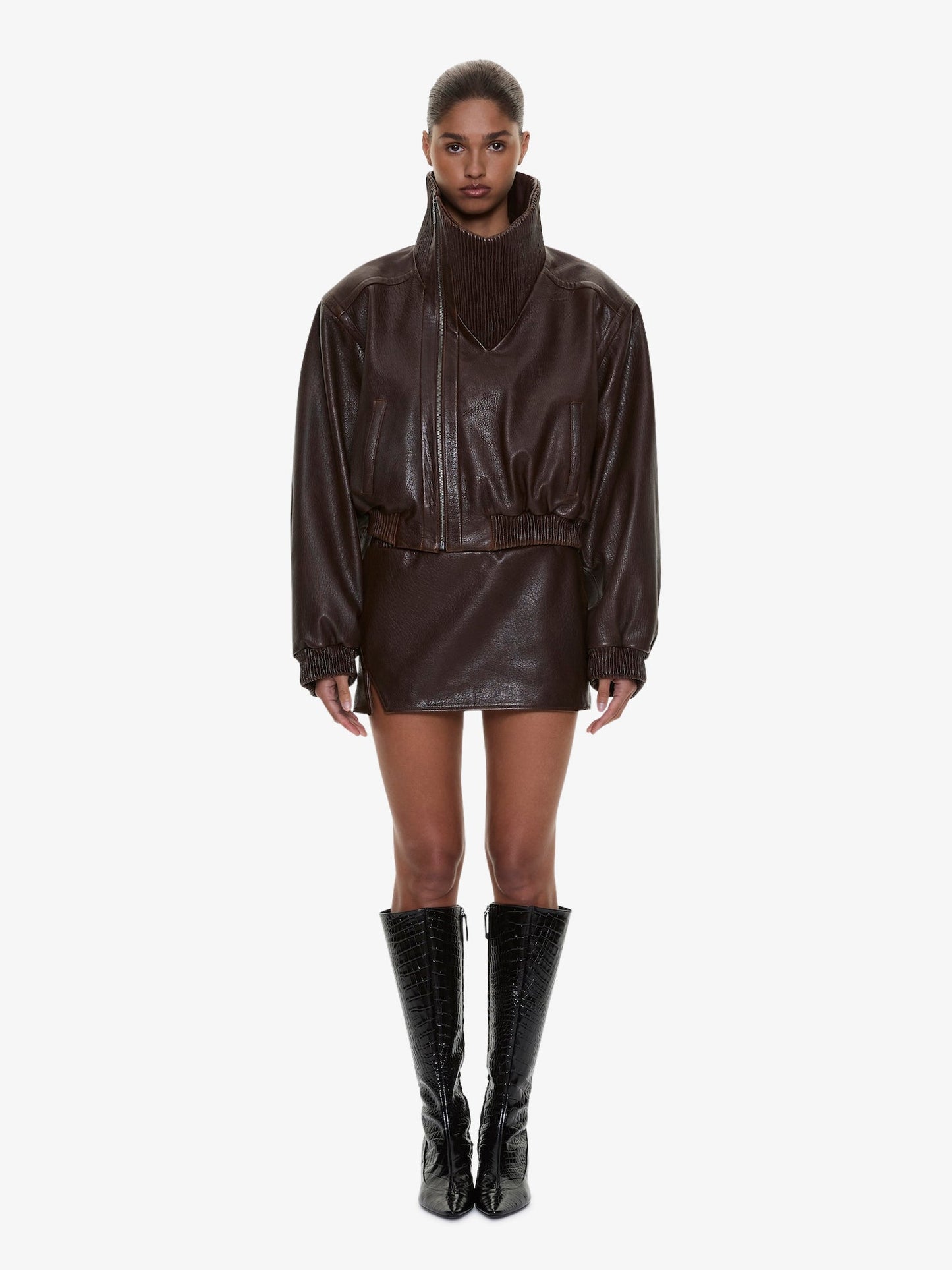 Image of a model wearing Skirts. Product name - Alfie Leather Mini Skirt in Brown colour by brand - CHRISTOPHER ESBER