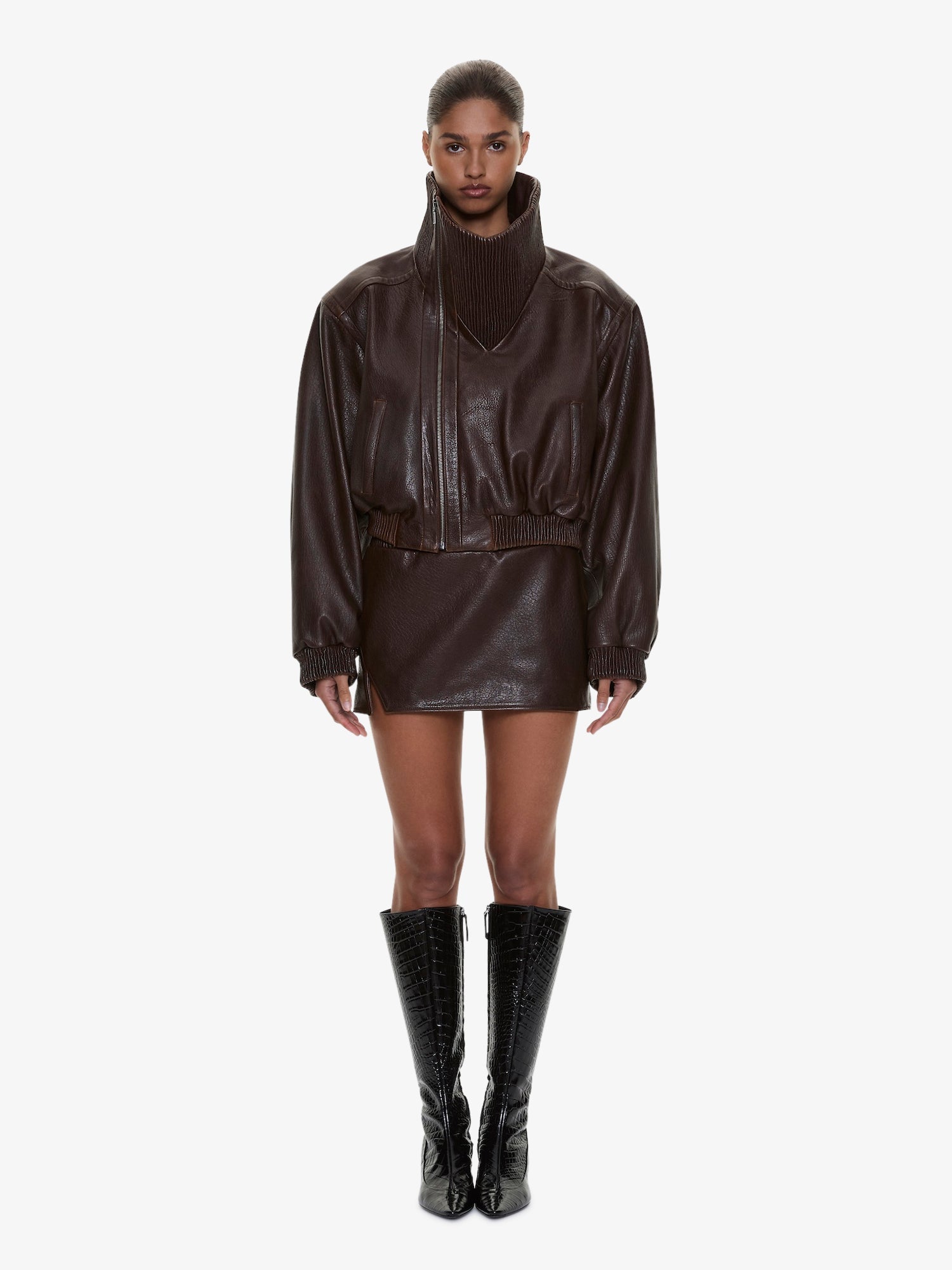 Image of a model wearing Skirts. Product name - Alfie Leather Mini Skirt in Brown colour by brand - CHRISTOPHER ESBER
