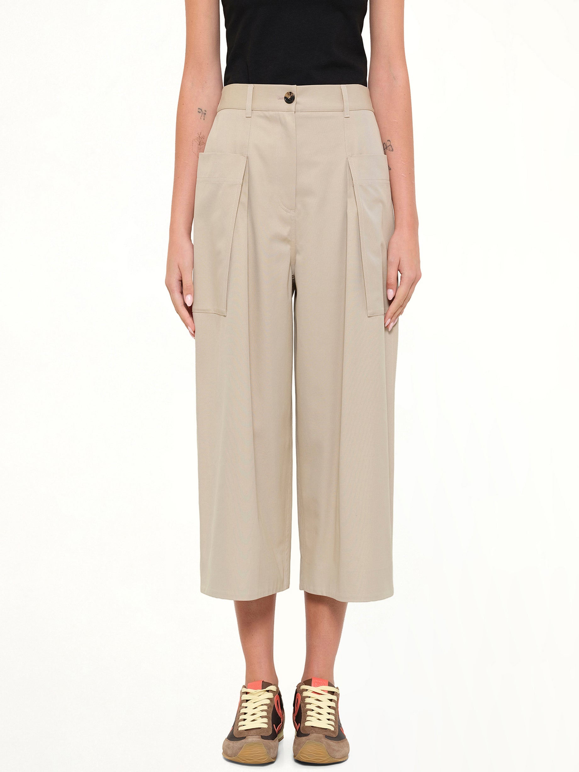 Image of a model wearing Pants. Product name - Cropped Trousers in Beige colour by brand - LOEWE
