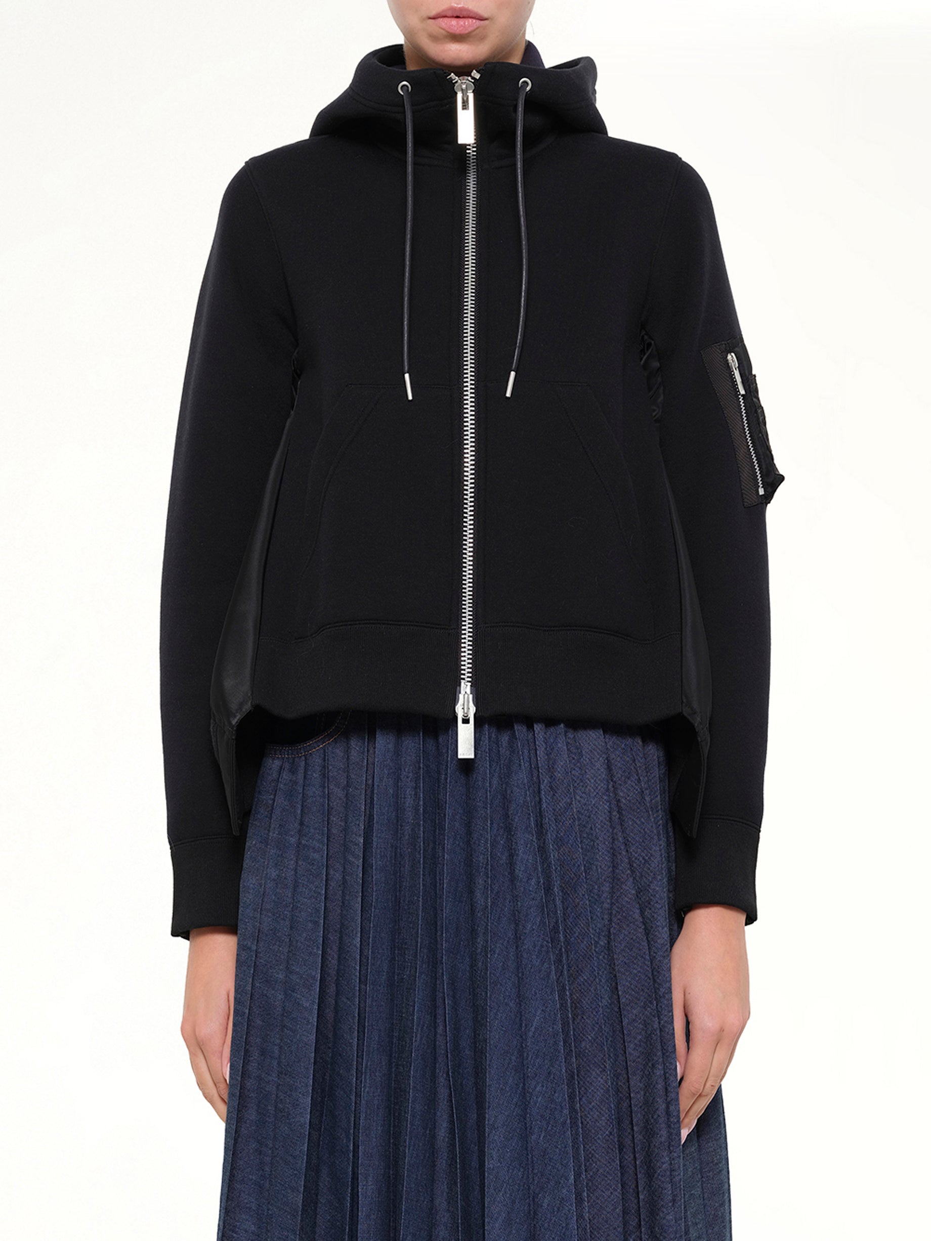 Image of a model wearing Outerwear. Product name - Sponge Sweat x Nylon Twill Hoodie in Black colour by brand - SACAI