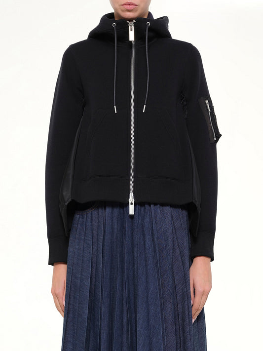 Image of a model wearing Outerwear. Product name - Sponge Sweat x Nylon Twill Hoodie in Black colour by brand - SACAI