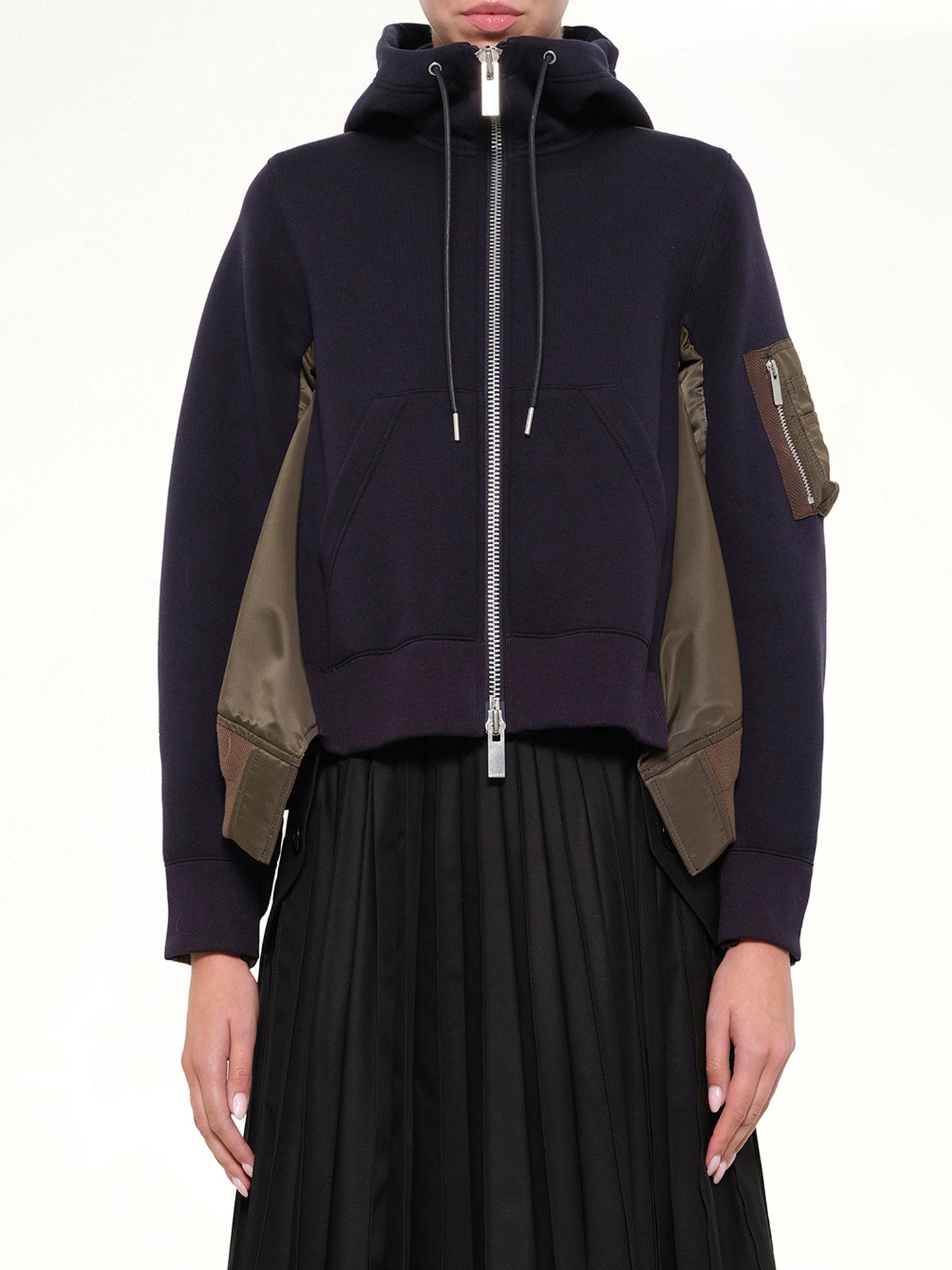 Image of a model wearing Outerwear. Product name - Sponge Sweat x Nylon Twill Hoodie in Navy colour by brand - SACAI