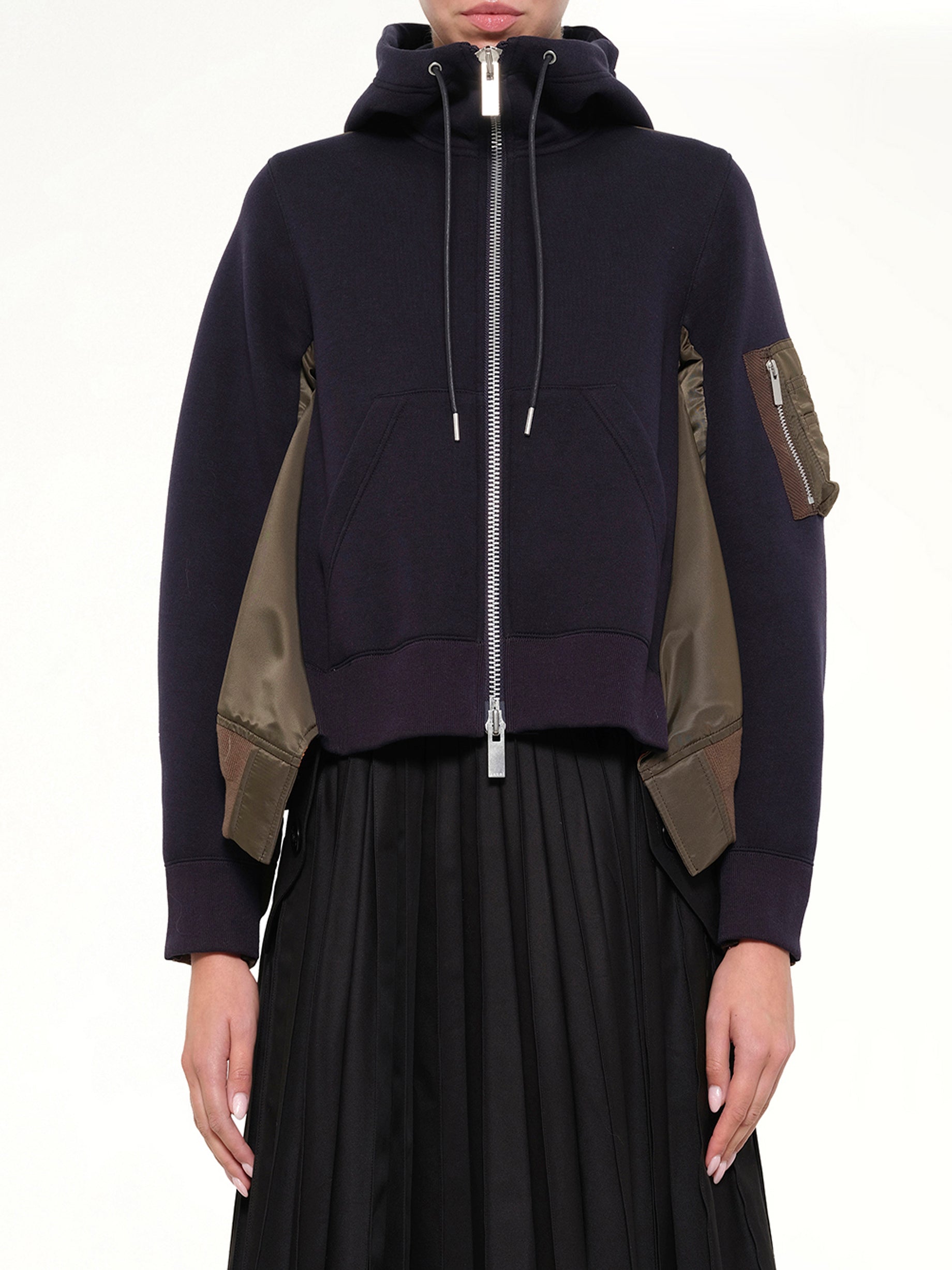 Image of a model wearing Outerwear. Product name - Sponge Sweat x Nylon Twill Hoodie in Navy colour by brand - SACAI