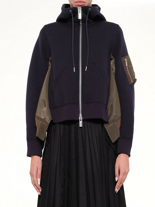 Image of a model wearing Outerwear. Product name - Sponge Sweat x Nylon Twill Hoodie in Navy colour by brand - SACAI