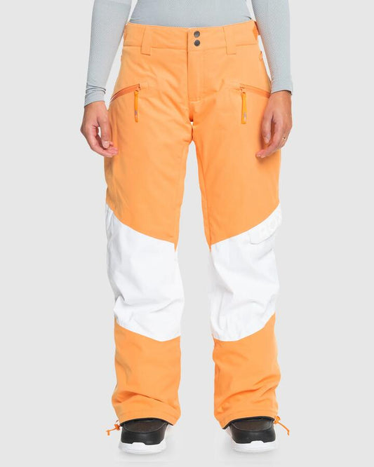 Image of a model wearing Pants. Productname: Roxy Womens Chloe Kim Woodrose Snow Pants Mock Orange - in Mock Orange colour by brand - Roxy