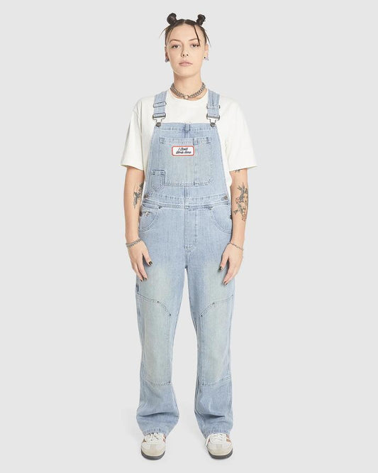Image of a model wearing Pants. Product name - Worship Womens Double Knee Denim Jumpsuit Overalls Dirty Trade Blue in Dirty Trade Blue colour by brand - Worship