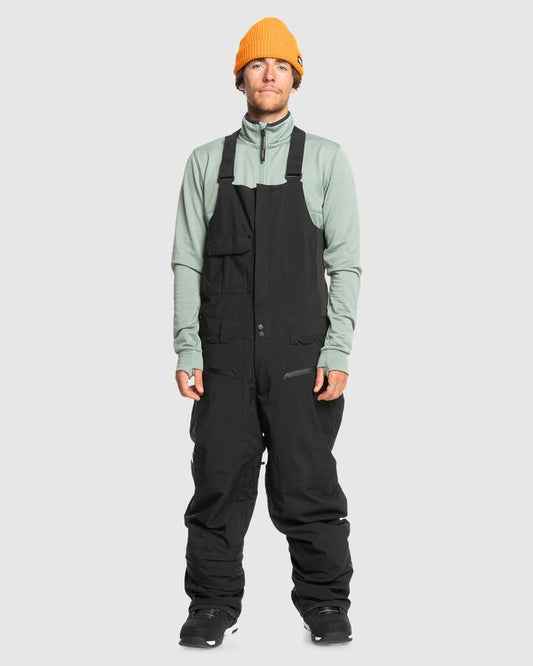 Image of a model wearing Pants. Productname: Quiksilver Mens Utility Bib Snow Pants True Black - in True Black colour by brand - Quiksilver