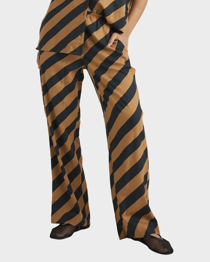 Image of a model wearing Pants. Product name - RVCA Womens Milspec Stripe Holiday Elastic Waist Pants Camel in Camel colour by brand - RVCA