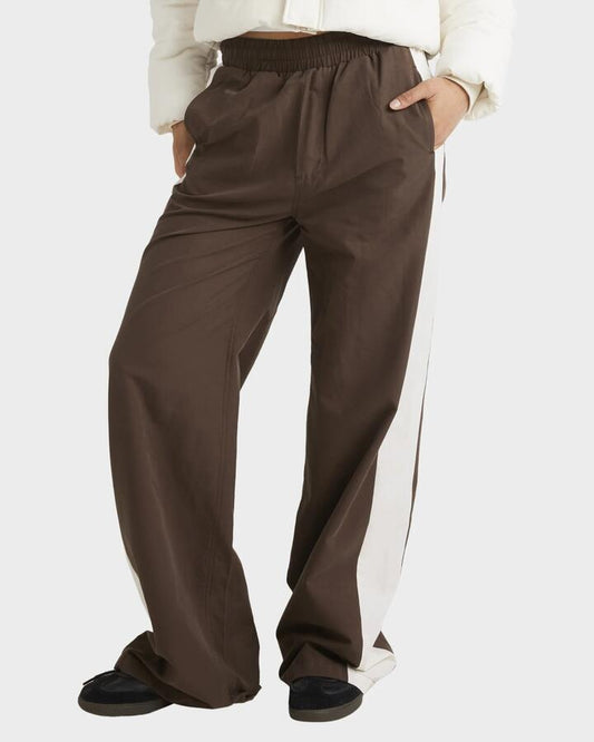 Image of a model wearing Pants. Productname: RVCA Womens Tracked Wide Leg Pants Chocolate - in Chocolate colour by brand - RVCA