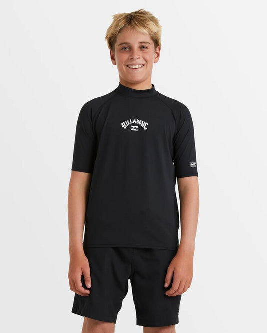 Image of a model wearing Tops. Productname: Billabong Boys 8-16 All Day Arch Short Sleeve Rash Vest Black - in Black colour by brand - Billabong