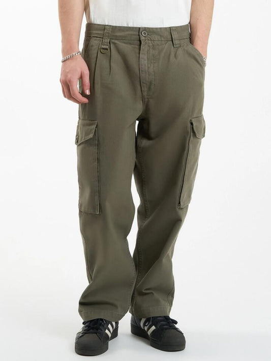 Image of a model wearing Pants. Productname: Thrills Issued Big Slacker Cargo Pant in Mild Army colour by brand - Thrills