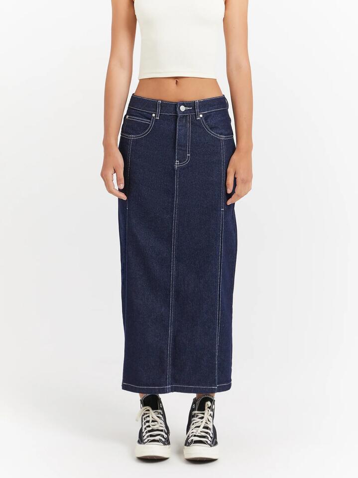 Image of a model wearing Skirts. Productname: Beyond Her Maeve Raw Indigo Low Rise Denim Midi Skirt Thigh Split in Raw Indigo colour by brand - Beyond Her