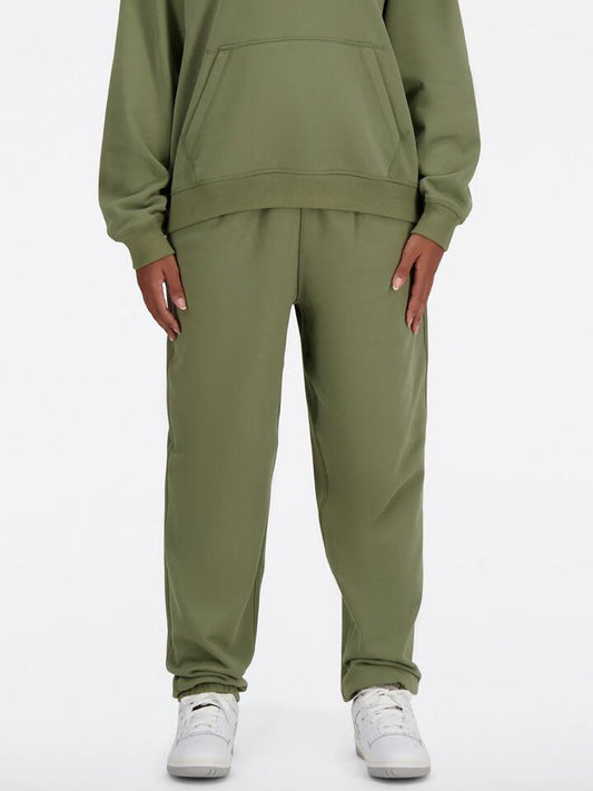 Image of a model wearing Pants. Productname: New Balance Athletics French Terry Jogger in Dark Olivine colour by brand - New Balance