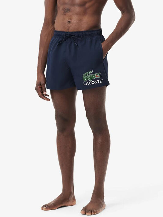 Image of a model wearing Shorts. Productname: Lacoste Core Originals Swim Short in Navy Blue colour by brand - Lacoste