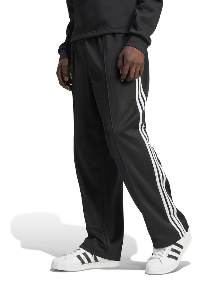 Image of a model wearing Pants. Productname: Adidas Mens Baggy Track Pant in Black colour by brand - Adidas