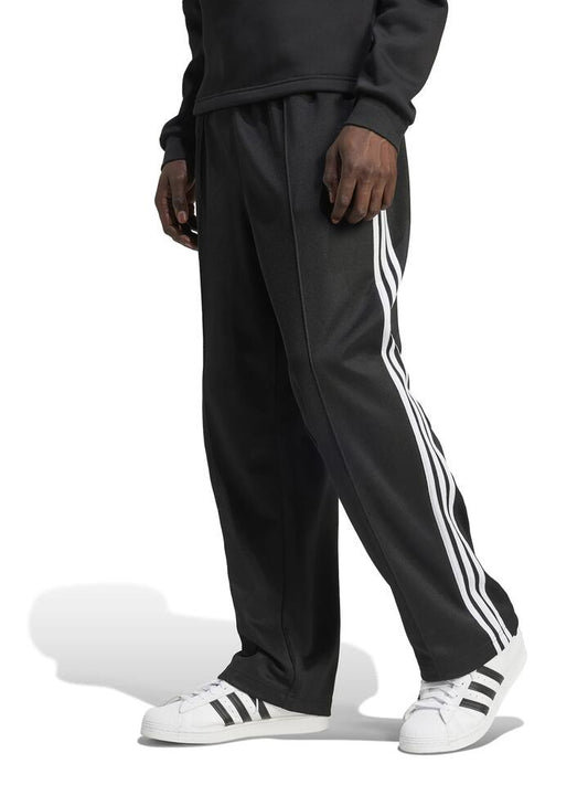 Image of a model wearing Pants. Productname: Adidas Mens Baggy Track Pant in Black colour by brand - Adidas