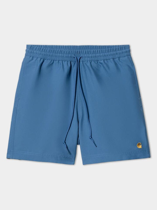 Image of a model wearing Shorts. Productname: Carhartt Wip Chase Swim Trunks in Acapulco/Gold colour by brand - Carhartt Wip