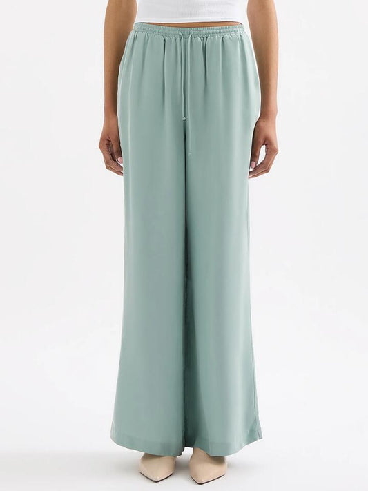 Image of a model wearing Pants. Productname: Nude Lucy Rika Cupro Pant in Capri colour by brand - Nude Lucy