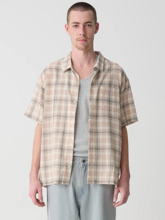 Image of a model wearing Shorts. Productname: Xlarge Wash Short Sleeve Shirt in Brown colour by brand - Xlarge