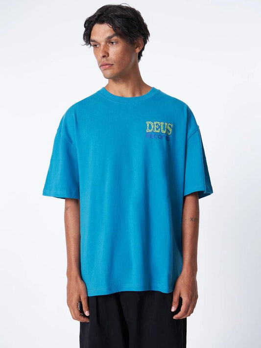 Image of a model wearing Tops. Productname: Deus Cave Dweller Tee in Wave Ride colour by brand - Deus