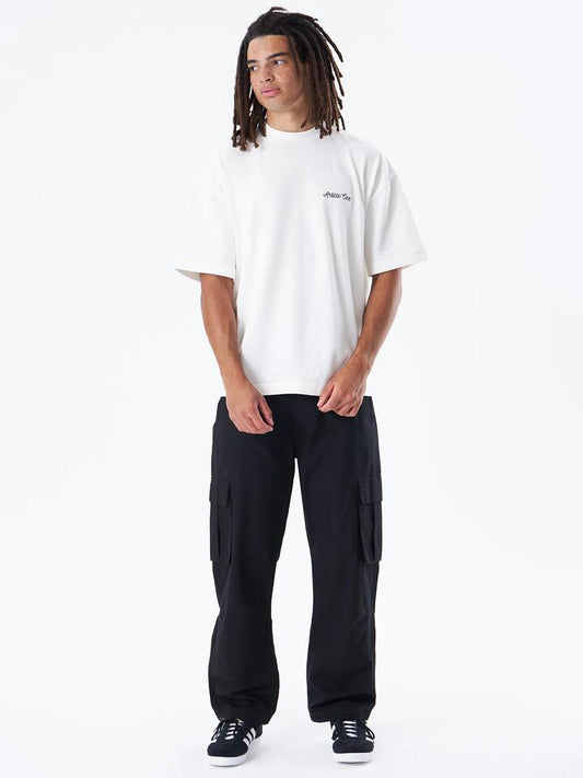 Image of a model wearing Tops. Productname: Article One Chainstitch Logo Tee in Natural colour by brand - Article One