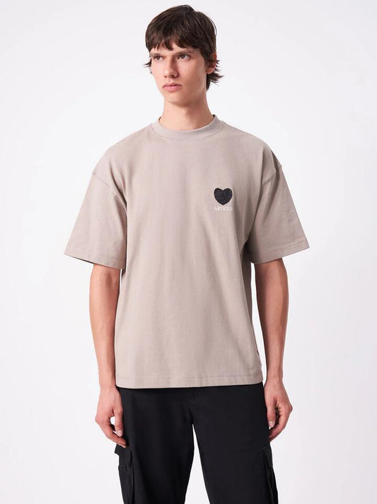 Image of a model wearing Tops. Productname: Article One Article Heart Tee in Oatmeal colour by brand - Article One