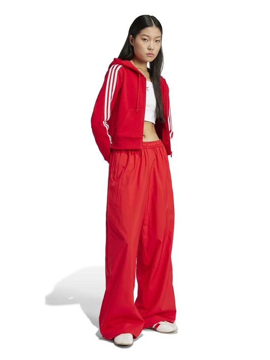 Image of a model wearing Pants. Productname: Adidas Woven Track Pants in Better Scarlet colour by brand - Adidas