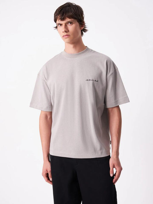Image of a model wearing Tops. Productname: Article One Leaves Tee in Ash colour by brand - Article One
