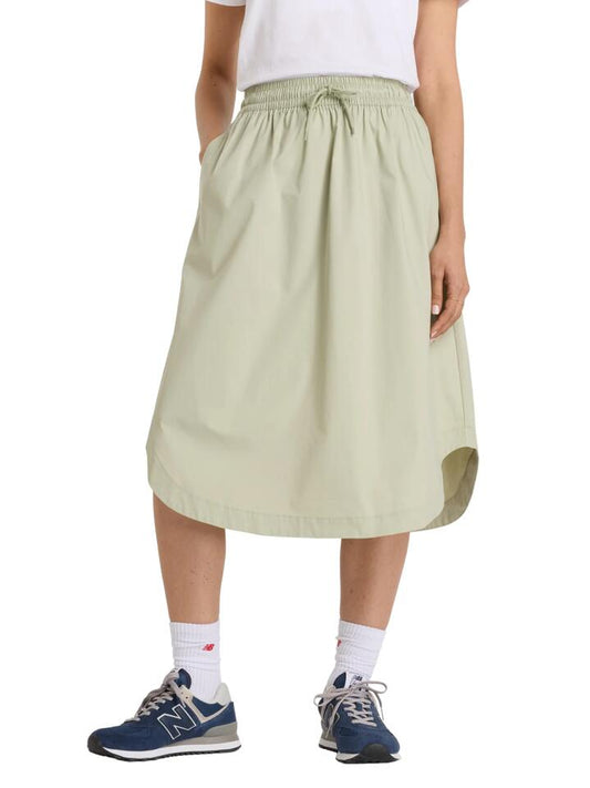 Image of a model wearing Skirts. Productname: New Balance Twill Midi Skirt in Olivine colour by brand - New Balance