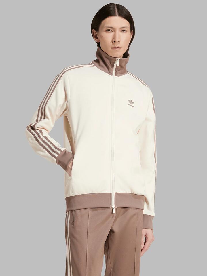 Image of a model wearing Tops. Productname: Adidas Mens Classic Track Top in Wonder White/Trace Brown colour by brand - Adidas